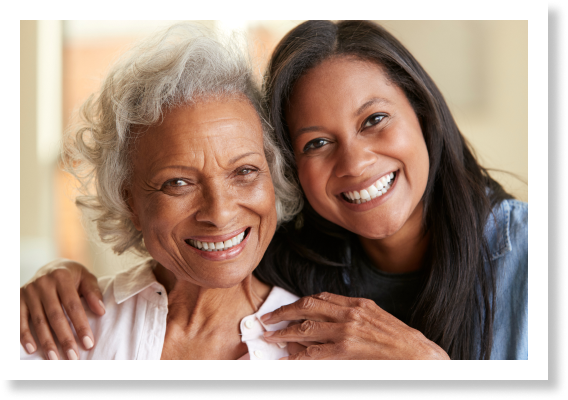 Senior mother receiving a warm hug from her caregiver daughter